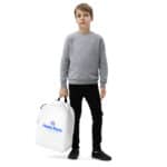 A young boy stands against a white background, dressed in a gray sweatshirt, black pants, and sneakers. he holds a HR Urban Voyager Backpack featuring a blue logo that reads "hasty rank" in his right hand.