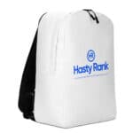 A HR Urban Voyager backpack with black zippers stands upright. It features a bold blue logo with the text "hasty rank" and a smaller caption "an ai-service digital marketing website design company" centered on the front.