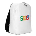 A white SEO Minimalist Backpack stands upright featuring the word "seo" in green, yellow, and red, with a blue infinity symbol replacing the letter 'o', placed on a plain background. The bag has black accents on its side and straps.
