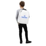 A young boy stands facing away, wearing a gray sweater, black pants, and shoes, carrying a HR Urban Voyager Backpack with blue trim and the "hasty rank" logo in blue on the back. white background.