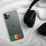 A smartphone with a SEO Clear Case for iPhone®, displaying colorful "seo" lettering on its screen, lies on a white fluffy fabric. beside it, black headphones partially extend into the frame.