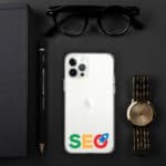Flat lay of modern essentials including a smartphone with "SEO Clear Case for iPhone®" on its case, a gold wristwatch, black sunglasses, a pencil, and a notebook on a dark background.