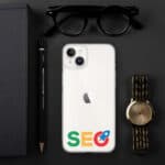 A white smartphone with an "SEO Clear Case for iPhone®" logo on its back, surrounded by a black notebook, a pencil, sunglasses, and a gold wristwatch, all arranged neatly on a dark surface.