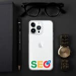 An iPhone with an "SEO Clear Case for iPhone®" logo on its back, accompanied by a black notebook, a pencil, sunglasses, and a gold wristwatch, all arranged on a dark surface.