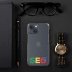 Flat lay of an SEO Clear Case for iPhone® with a google seo sticker on the back, a gold wristwatch, black sunglasses, a black notebook, and a pencil, all arranged on a dark gray background.