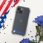 A HR CrystalShield iPhone® Case containing an iPhone, placed diagonally on a white background with an American flag, blue flowers, and scattered red and blue stars. The case has a "hasty rank" logo at the bottom.