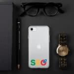 Flat lay of modern accessories on a dark background: a smartphone with an SEO Clear Case for iPhone®, eyeglasses, a black notebook, a pencil, and a gold wristwatch.