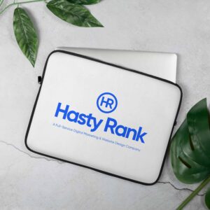 A white HR TechGuard Laptop Sleeve with the "hasty rank" logo, a digital marketing and website design company, displayed prominently on top, resting on a grey marble surface alongside green leaves.