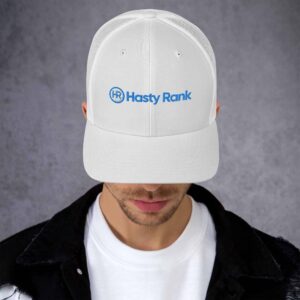 A man wearing a white HR SunStride Cap with the logo "hasty rank" in blue, set against a gray background. his face is partly obscured, focusing attention on the hat.
