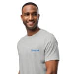 A black man smiling, wearing a HR PrimeStyle Tee with the "hastyrank" logo, looking slightly to his right, set against a plain white background.