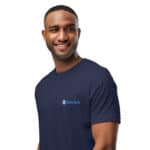 A smiling black man wearing a dark blue HR PrimeStyle Tee with a logo that reads "hasty rank" on the chest. He stands against a plain white background, looking confidently towards the camera.